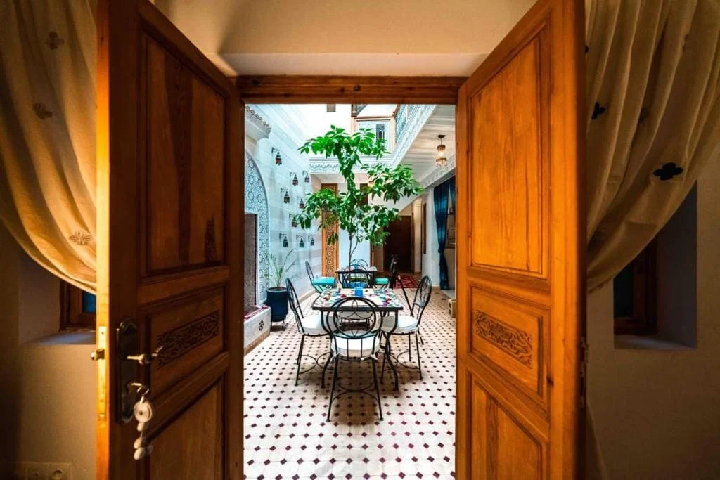 Charming Marrakech riad courtyard with outdoor seating and lush greenery.