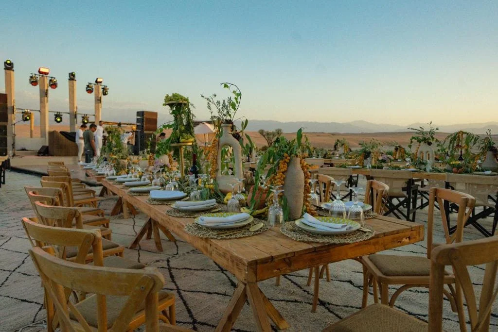 Elegant outdoor dining setup with rustic wooden tables and chairs.