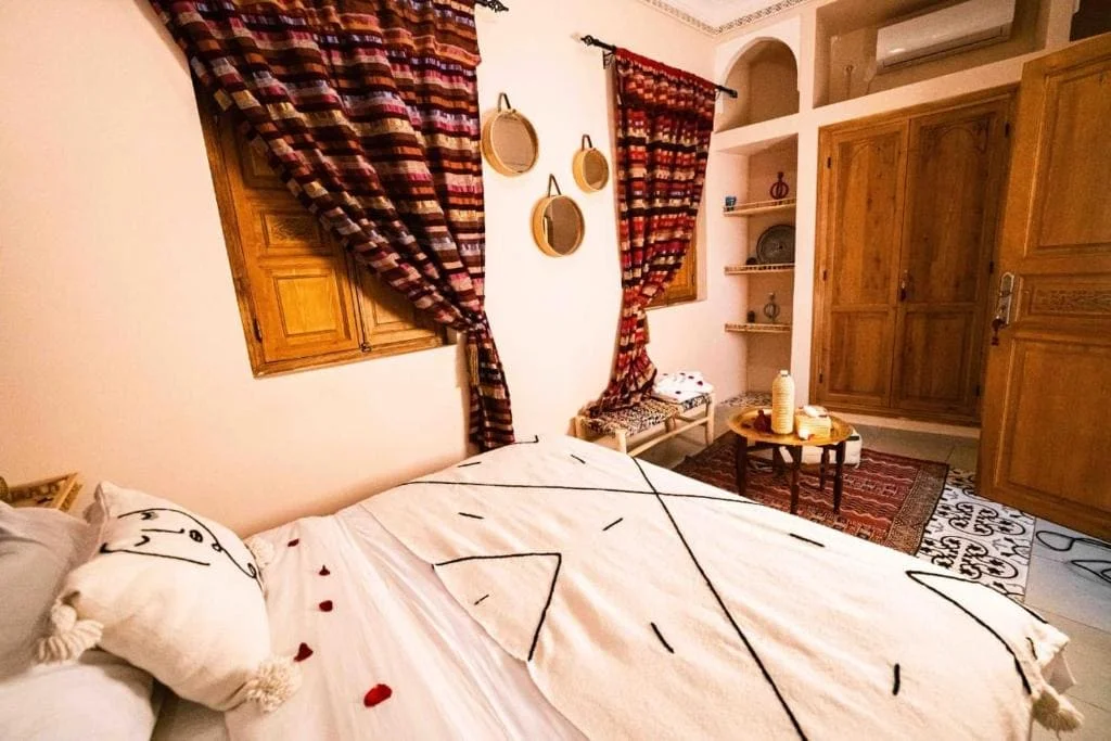 Cozy bedroom with wooden furniture and patterned curtains in Marrakech.
