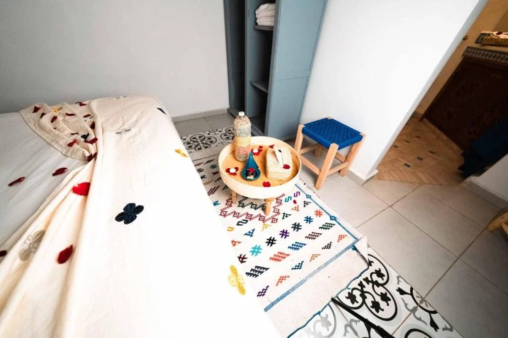 Child's bedroom with bed, toys, and colorful rug in a modern home.