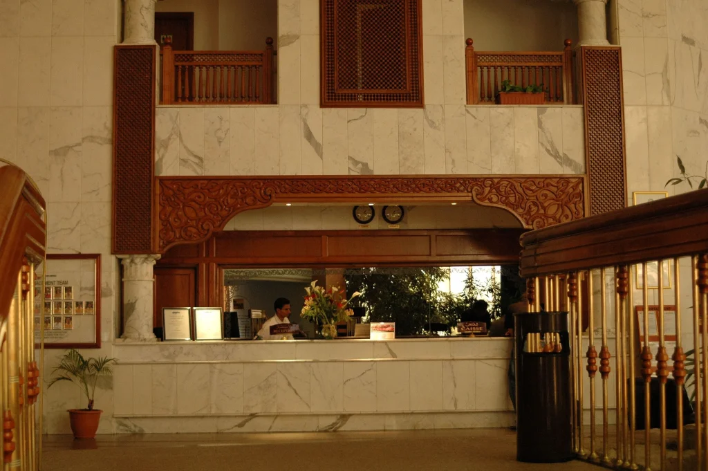 Luxurious hotel reception area with marble walls and detailed woodwork design.
