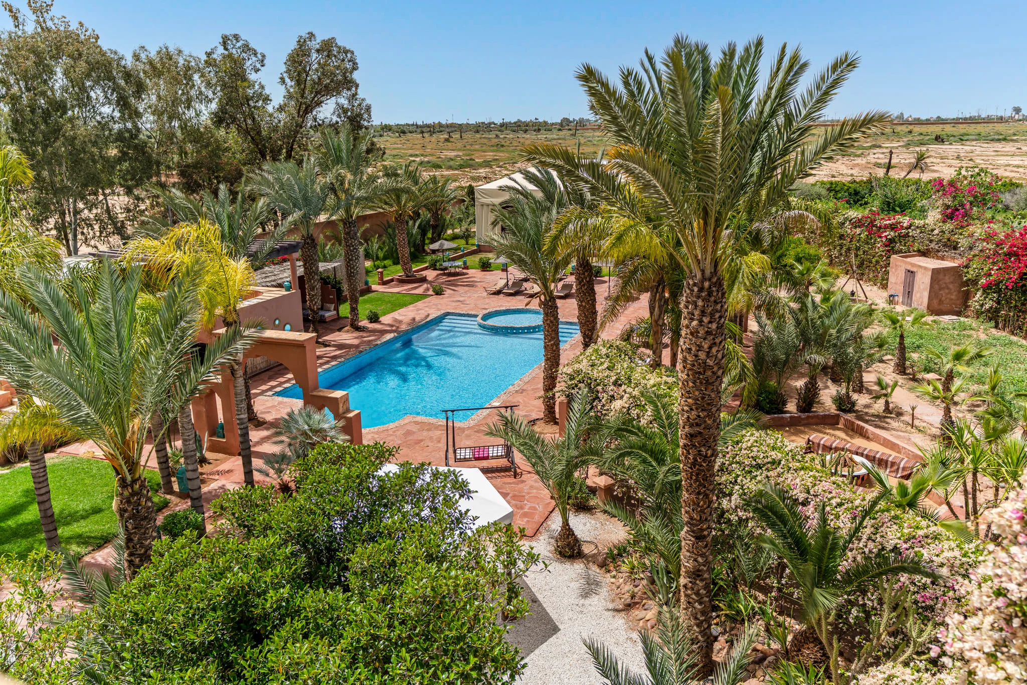 Luxury pool surrounded by palm trees and lush greenery at Locanda Boutique Collection.