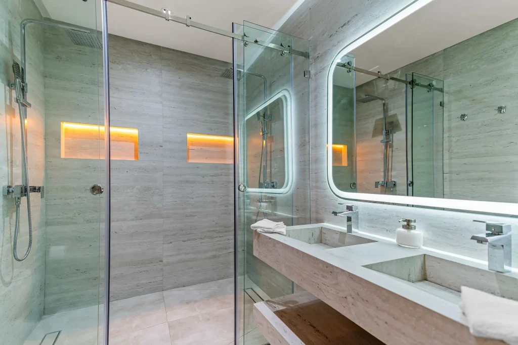 Contemporary bathroom with glass shower, double sink, and sleek design.