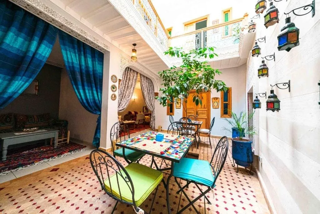 Charming Marrakech riad courtyard with colorful decor and seating area.