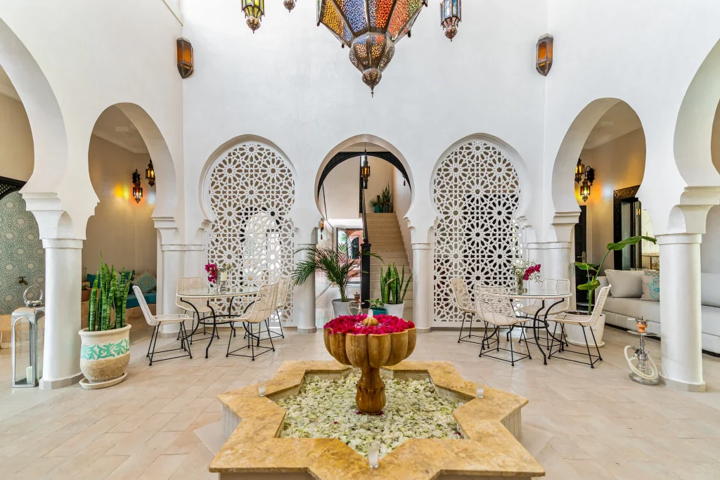 Elegant hotel lobby with Moroccan-inspired decor and central fountain.