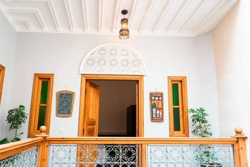 Elegant Moroccan interior with wooden accents and green plants.