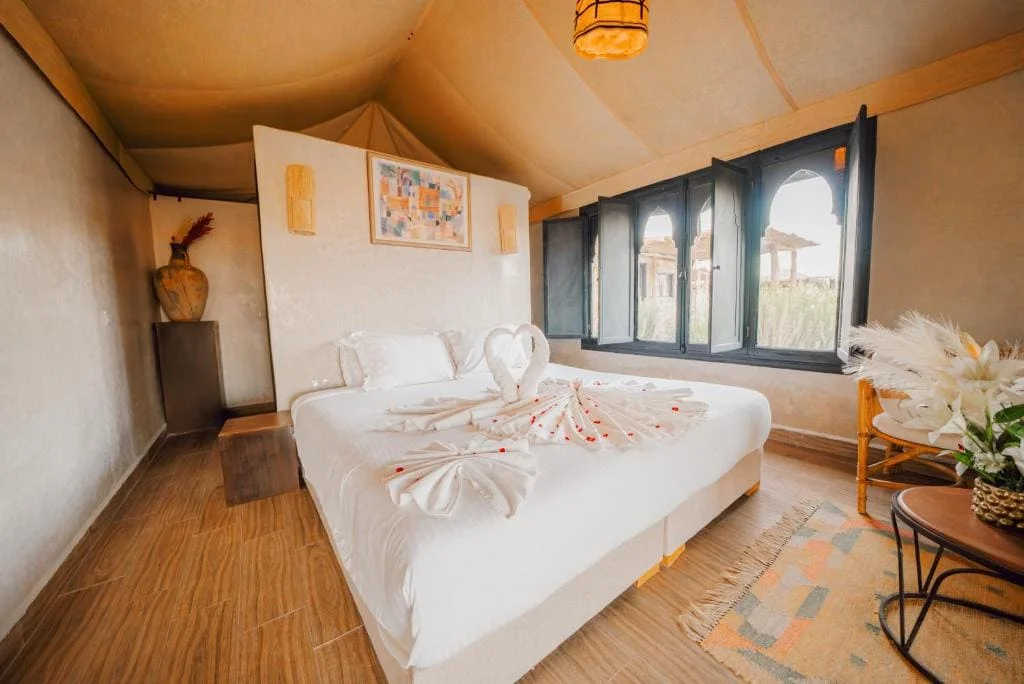 Cozy bedroom with swan towel art and large windows at Locanda Boutique Collection.