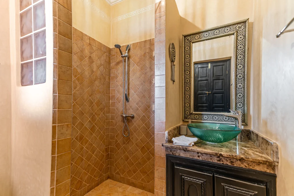 Elegant bathroom with walk-in shower and decorative mirror.