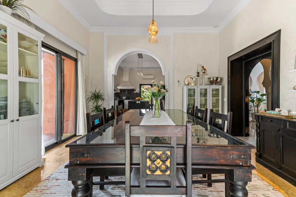 Stylish dining room with dark wood table, white walls, and modern decor.